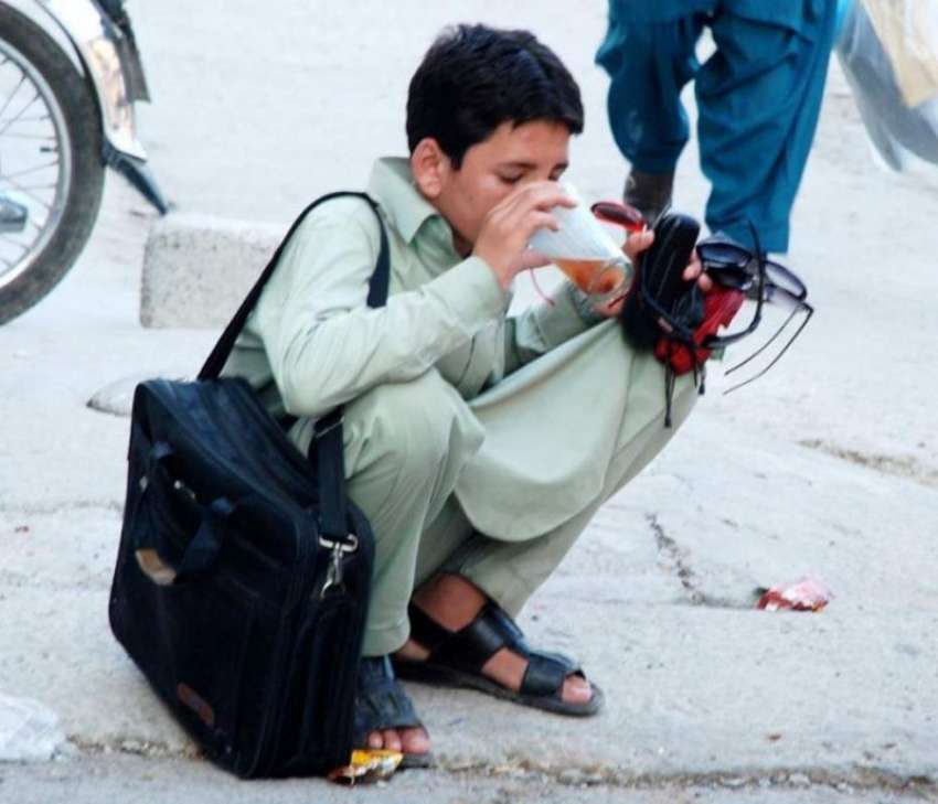 راولپنڈی: گرمی کی شدت کو کم کرنے کے لیے محنت کش بچہ فٹ پاتھ ..