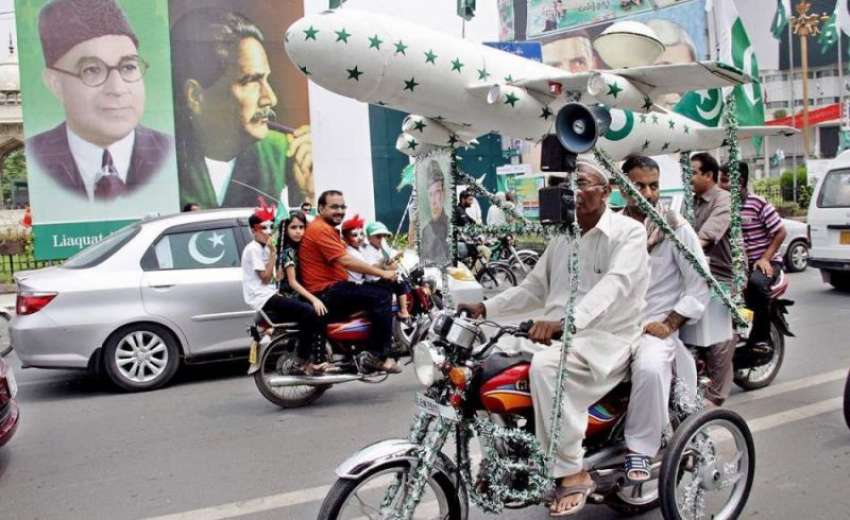لاہور: جشن آزادی کے موقع پر شہری موٹر سائیکل پر جہاز کا ماڈل ..