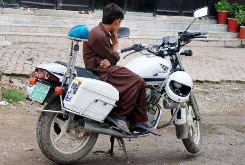 راولپنڈی: ٹریفک پولیس اہلکار کی موٹر سائیکل پر بیٹھا ایک ..