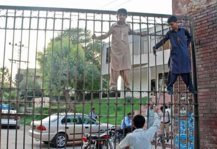 راولپنڈی: لیاقت باغ کے گیٹ پر چڑھے بچے کھیل کود میں مصروف ..