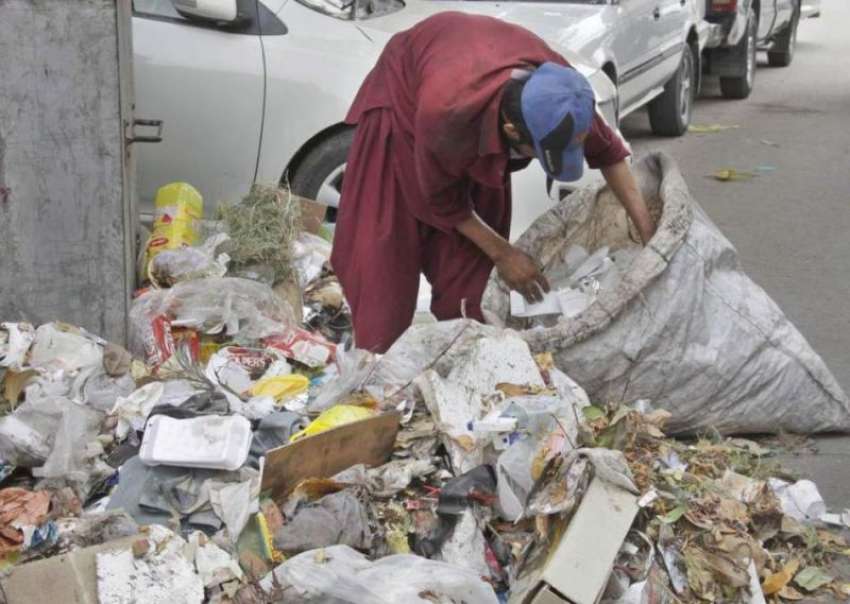 لاہور: ایک خانہ بدوش کوڑے کے ڈھیر سے کاغذ اکٹھے کر رہا ہے۔