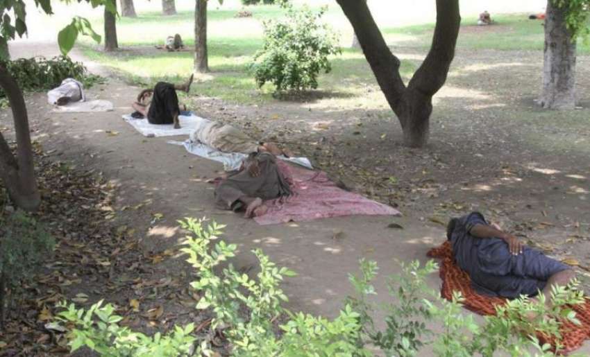 لاہور: مقامی پارک میں دوپہر کے وقت لوگ درختوں کے سائے تلے ..