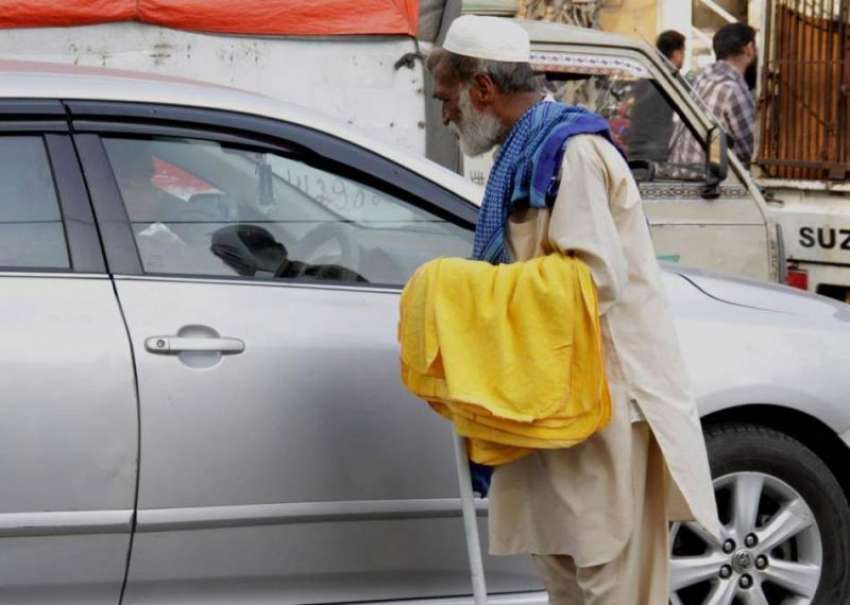 لاہور: ایک ضعیف العمر شخص ٹریفک سگنل پر گاڑیاں صاف کرنے واہے ..