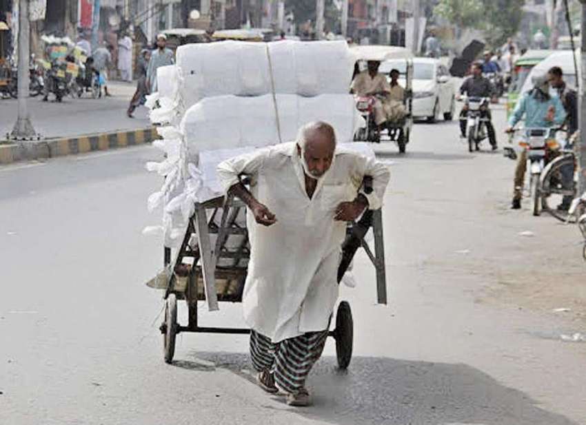 لاہور: ایک محنت کش ہتھ ریڑھی پر سامان رکھے اپنی منزل کی جانب ..