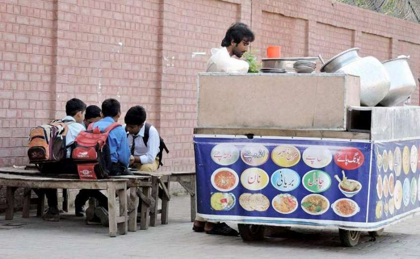 لاہور: طالبعلم سکول جانے سے قبل راوی روڈ فٹ پاتھ پر بیٹھے ..