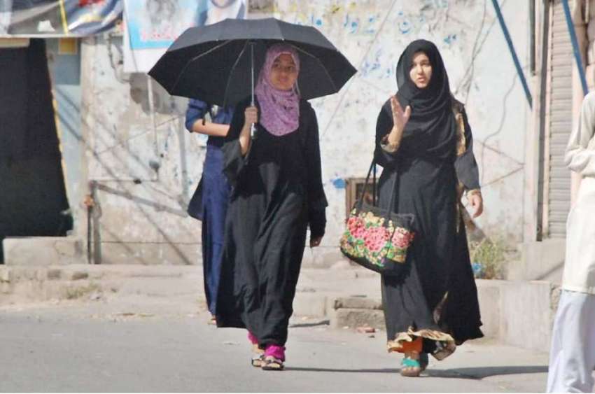 راولپنڈی: دھوپ سے بچنے کے لیے طالبات چھتری تانے منظرل کی ..