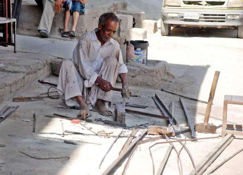 راولپنڈی: کاریگر اپنی ورکشاپ کے باہر کام میں مصروف ہے۔