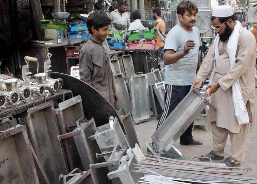 لاہور: عیدالااضحی کے آمد کے موقع پر شہری ایک دوکان سے لوہے ..