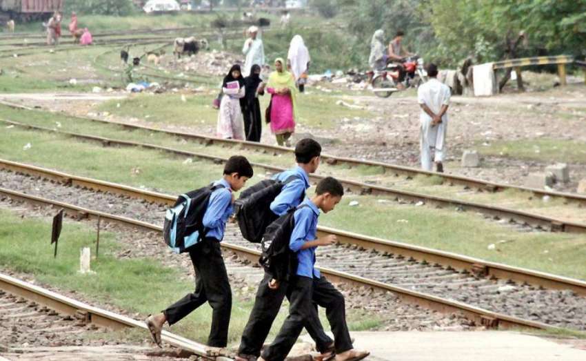 لاہور: بچے سکول سے چھٹی کے بعد گھر جانے کے لیے ریلوے لائن ..