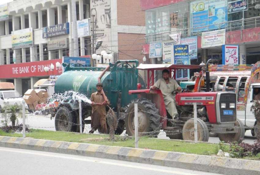 راولپنڈی: پی ایچ اے کا اہلکار گرین بیلٹ پر لگی گھاس کو پانی ..
