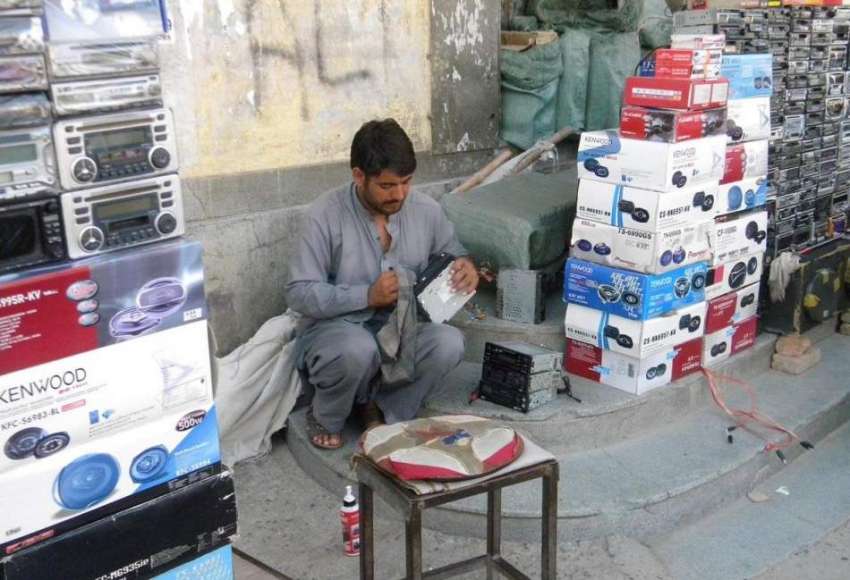 راولپنڈی: فٹ پاتھ پر بیٹھا محنت کش گاڑیوں میں لگانے والی ..