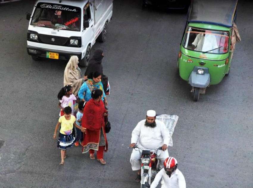 راولپنڈی: خواتین بچوں کے ہمراہ ٹریفک میں سڑک کراس کر رہی ..