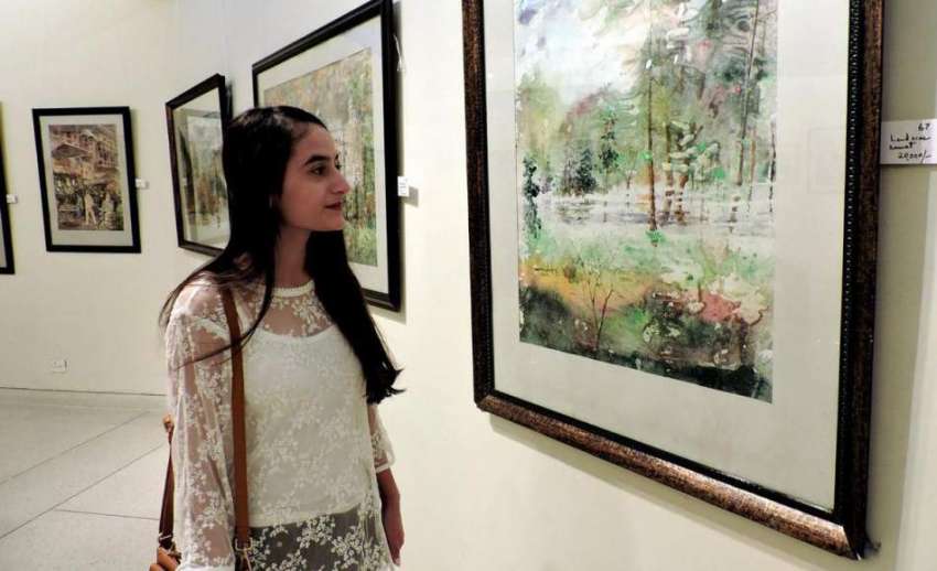 لاہور: الحمراء آرٹ گیلری میں ایک لڑکی پینٹنگ کی نمائش دیکھ ..