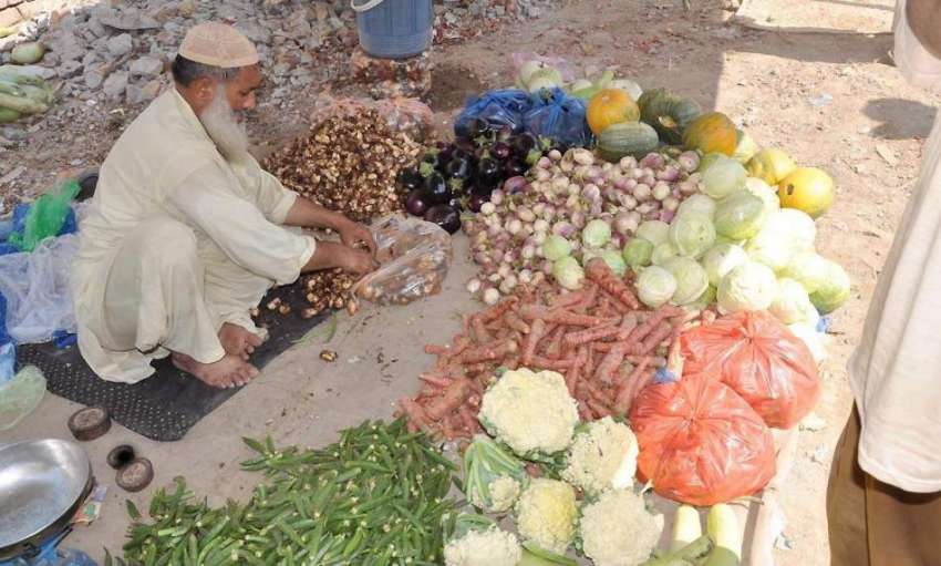 راولپنڈی: ہفتہ وار جمعہ بازار میں ایک سبزی فروش سبزی سجا ..