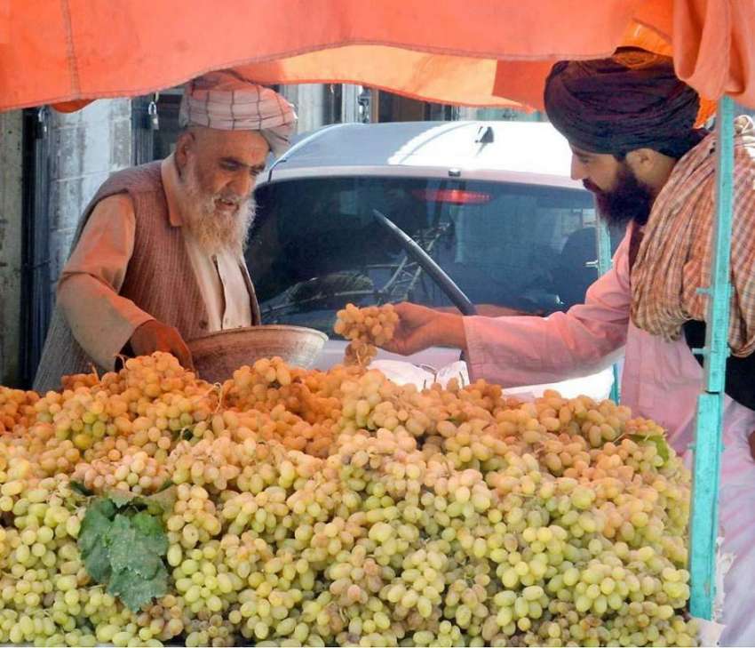 کوئٹہ: مسجد روڈ پر ایک شہری ریڑھی بان سے انگور خریدنے میں ..
