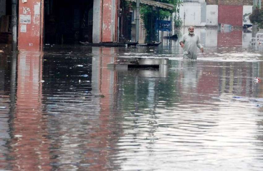 راولپنڈی: شدید بارش کے ملت بعد کالونی میں ایک شخص بارش کے ..