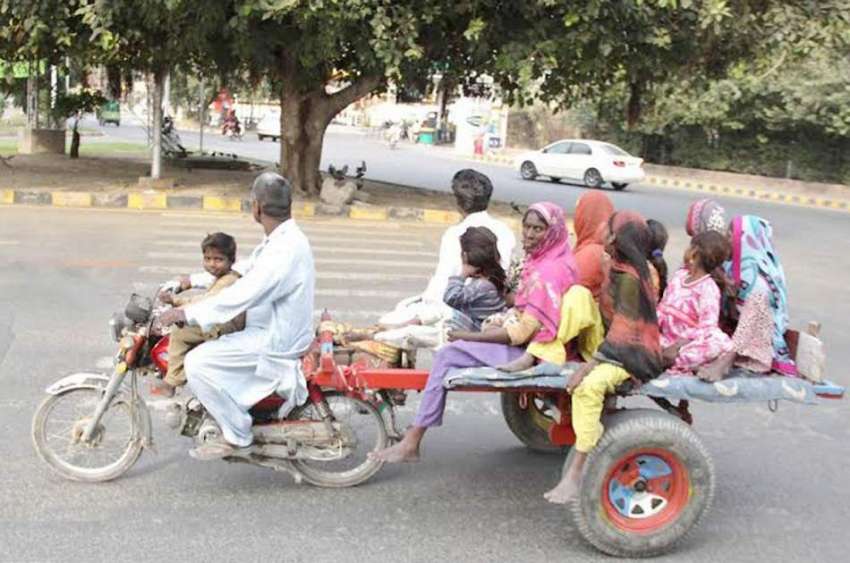 لاہور: ایک موٹر سائیکل سوار خانہ بدوش فیملی ایجرٹن روڈ سے ..
