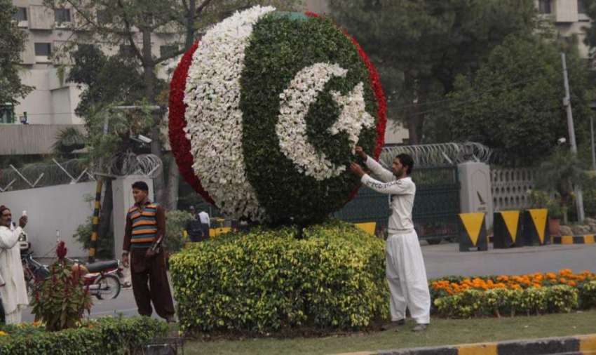 لاہور: پی ایچ اے کا ملازم مال روڈ پر پھولوں سے قومی پرچن تیار ..