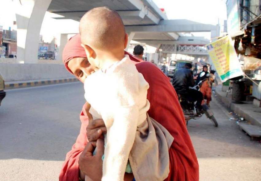 راولپنڈی: مری روڈ پر ایک خانہ بدوش خاتون اپنے بچے کو اٹھائے ..