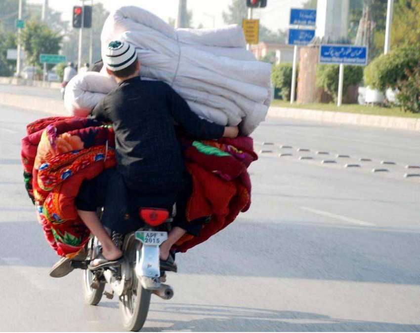 راولپنڈی: شہری موٹر سائیکل پر رضائیاں لیے اپنی منزل کی طرف ..