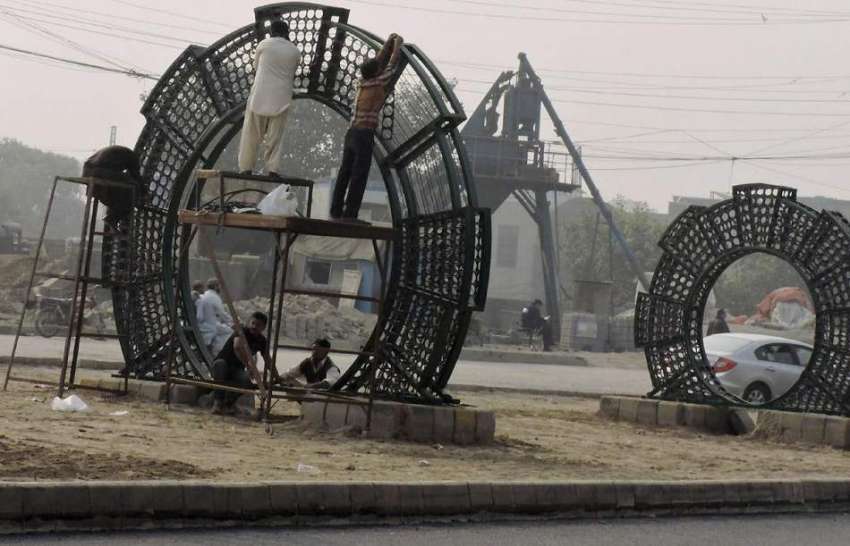 لاہور: پی ایچ اے کے ملازمین جیل روڈ پر گلدستے لگانے کے لیے ..