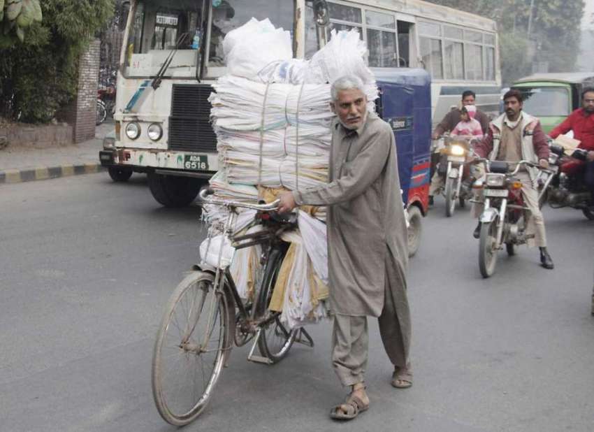 لاہور: ایک محنت کش خالی توڑی سائیکل پر رکھے جا رہا ہے۔