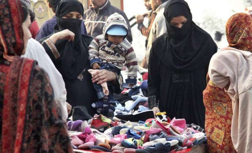 لاہور: خواتین لنڈا بازار میں ایک ریڑھی سے جوتے خرید رہی ہیں۔