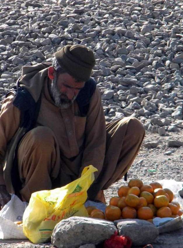 راولپنڈی: ایک محنت کش زمین پر بیٹھا کینوؤں کی دکان سجا رہا ..