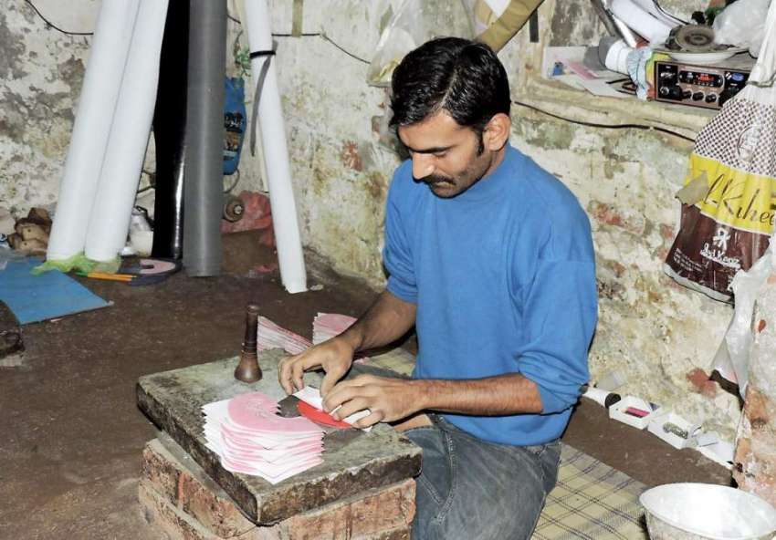 لاہور: مزنگ بازار میں ایک کاریگر جوتے تیار کر رہا ہے۔