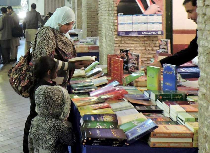 لاہور: ٹولٹن مارکیٹ میں کتابوں کی نمائش میں ایک خاتون کتابیں ..