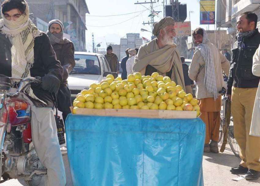 کوئٹہ: ایک بزرگ شہری سرکی روڈ پر ریڑھی میں سیب فروخت کر رہا ..