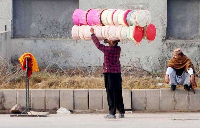 راولپنڈی: ایک محنت کش سر پر موڑھے رکھے فروخت کے لیے جا رہا ..