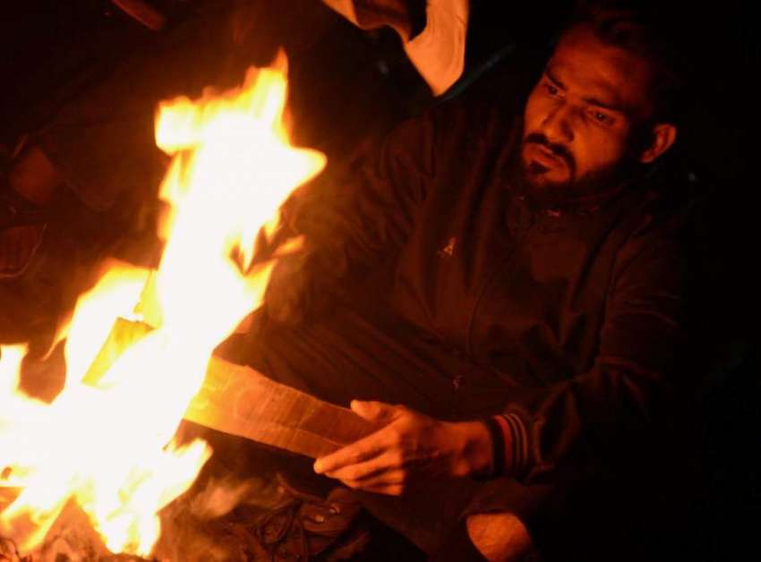 کراچی: ایک شخص سخت سردی سے بچنے کے لیے آگ تاپ رہا ہے۔