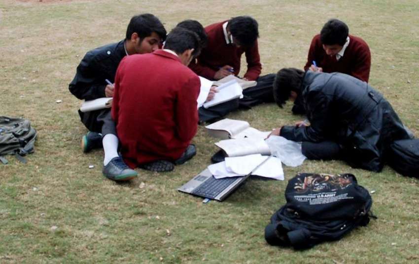 راولپنڈی: طلبہ مقامی پار میں بیٹھے ہوم ورک کر رہے ہیں۔