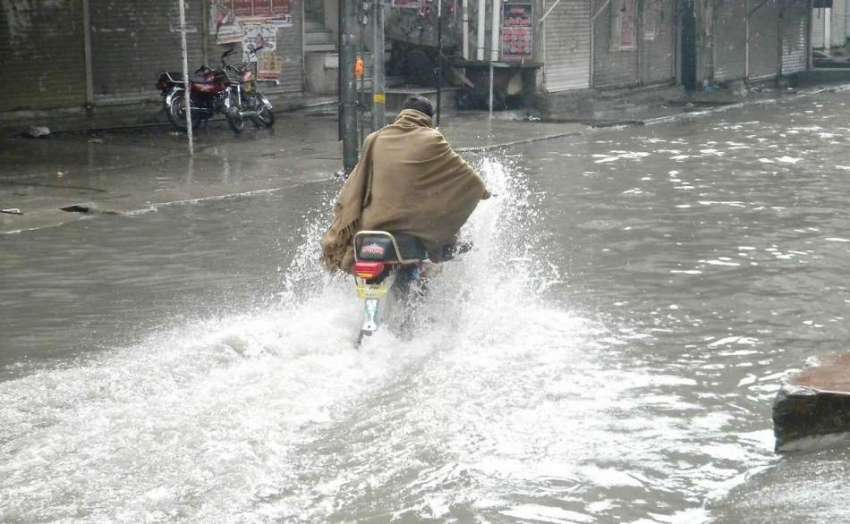 راولپنڈی: ایک موٹر سائیکل سوار بارش کے پانی سے گزر رہا ہے۔