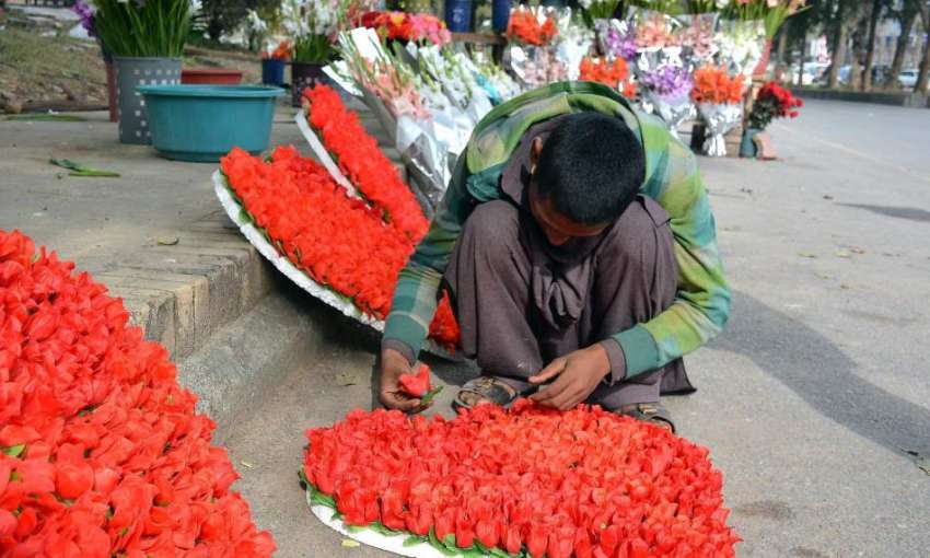 اسلام آباد: ایک محنت کش سڑک کے کنارے ویلنٹائن ڈے کی مناسبت ..