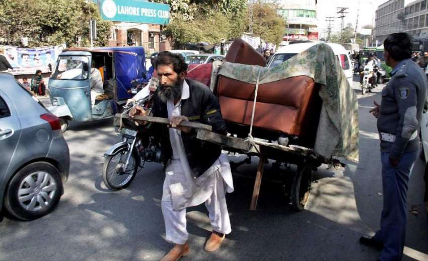 لاہور: ایک محنت کش ہتھ ریڑھی پر بھاری سامان رکھے پریس کلب ..