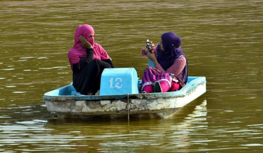 لاہور: خوشگوار موسم میں دوخواتین پارک میں کشتی رانی کی سیر ..