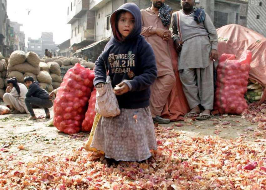 لاہور: سبزی منڈی میں ایک خانہ بدوش بچی تھیلے میں سبزیاں اکٹھی ..
