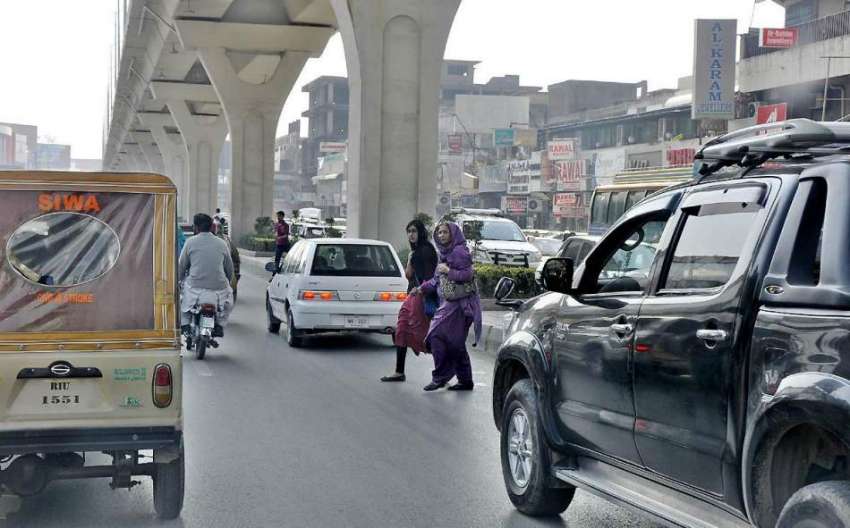 راولپنڈی: خواتین چلتی ٹریفک کے دوران روڈ کراس کر رہی ہیں ..