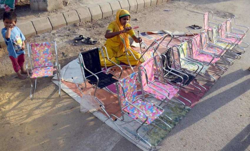 کراچی: ایک عورت سڑک کنارے اپنے بچے کے ہمراہ کرسیاں فروخت ..