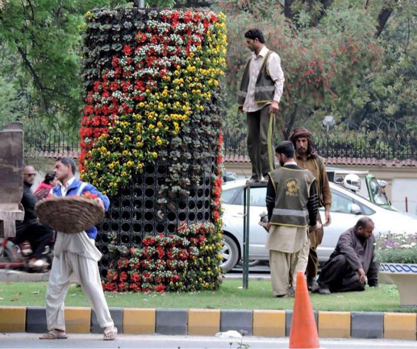 لاہور: مال روڈ پر پی ایچ اے کے ملازم گلدان میں نئے پھول لگا ..