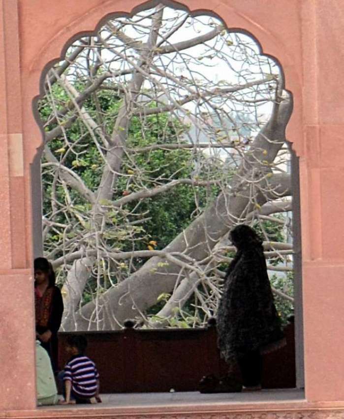 لاہور: ایک خاتون بادشاہی مسجد میں جمعہ کی نماز ادا کر رہی ..