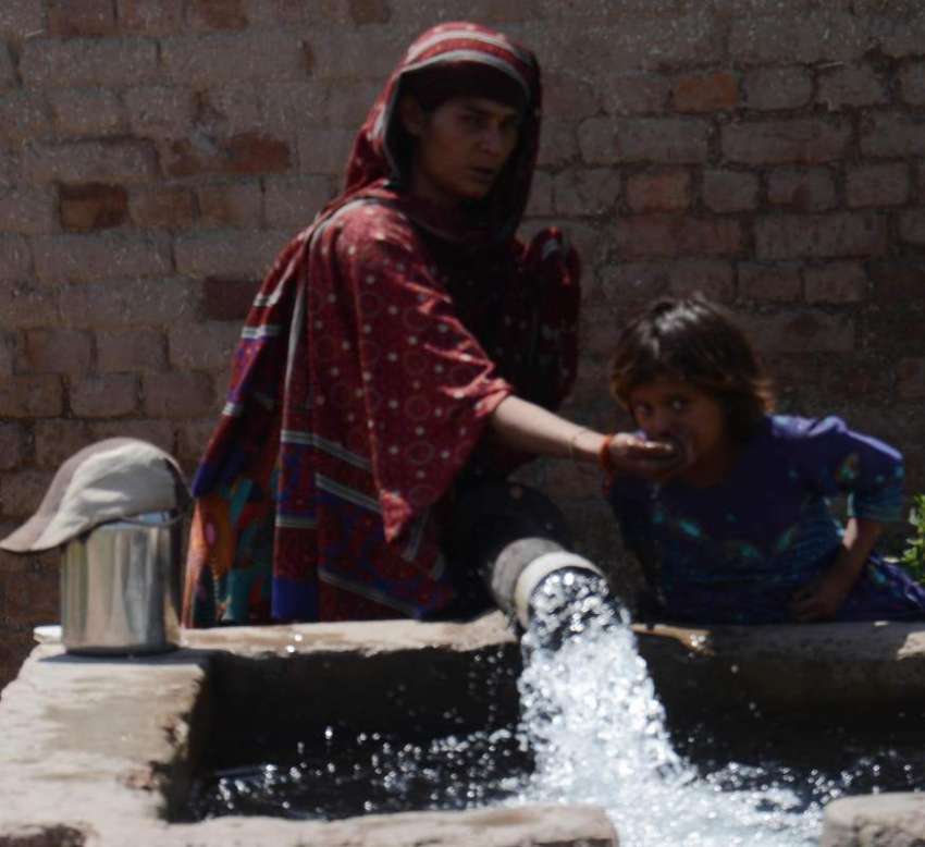 لاہور: خاتون شدید گرمی میں اپنی بچی کو ٹیوب ویل سے پانی پلا ..