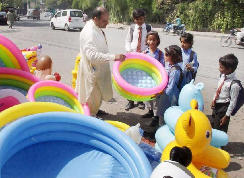لاہور: سکول سے چھٹی کے بعد بچے سڑک کنارے سجی دکان سے پلاسٹک ..