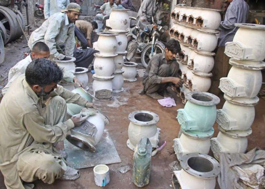 لاہور: لوہا مارکیٹ میں مزدور ٹیوب ویلز کی ٹی کو پینٹ کر رہے ..