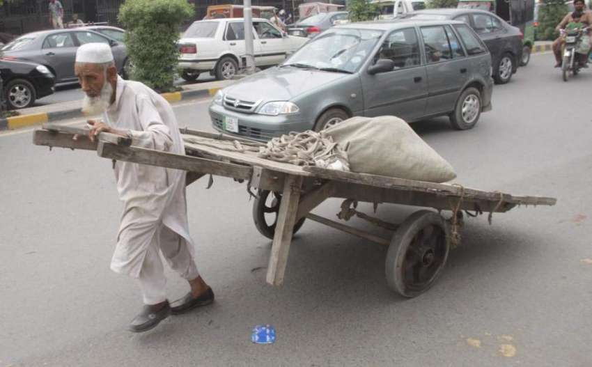 لاہور: ایک ضعیف العمر شخص ہتھ ریڑھی لے جا رہا ہے۔
