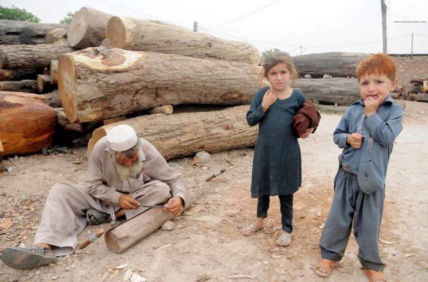 راولپنڈی:ایک افغان محنت کش لکڑیوں کی کٹائی کے لیے آری تیز ..