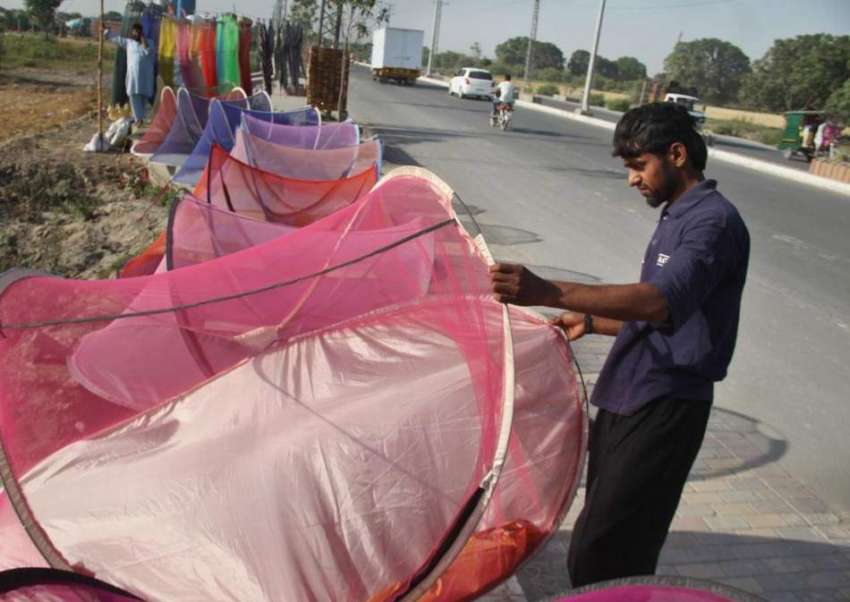 لاہور: ایک شخص مچھر دانیاں فروخت کرنے کے لیے کینال روڈ پر ..