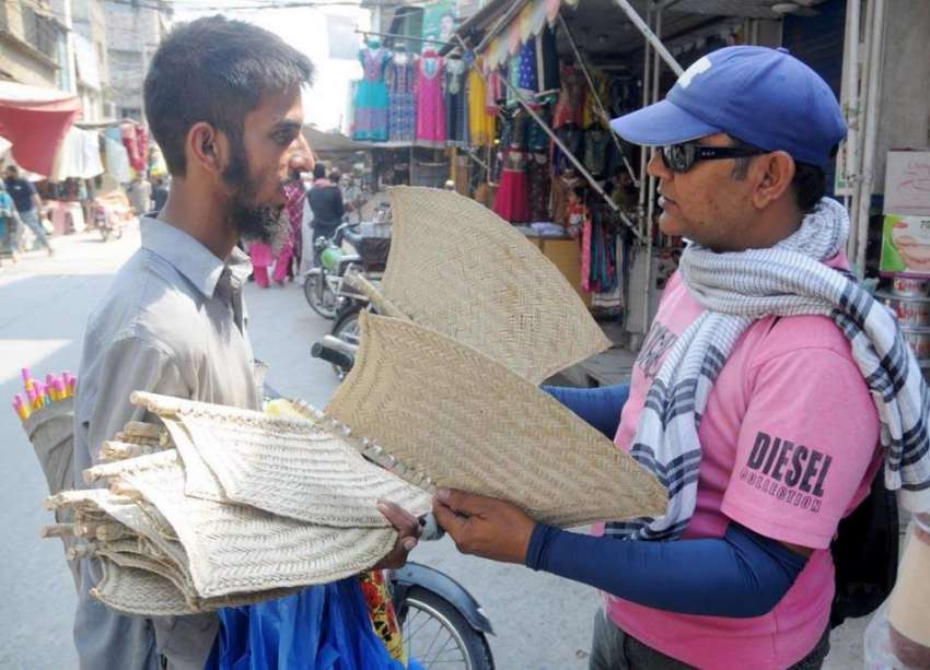 راولپنڈی: ایک محنت کش بازار میں ہاتھ والے پنکھے فروخت کر ..